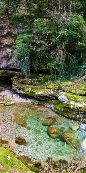 A waterfall in the mountains along a hiking path in Greece.